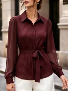 Detailed view of the burgundy striped long sleeve blouse featuring a chic belted waist.