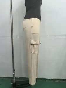 Detail view of women's beige cargo pants featuring side pockets and comfortable elastic waist.