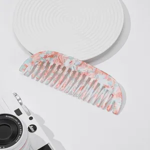 Acetate wide-tooth hair comb with pink and blue marbled design for daily hairstyling and beauty.