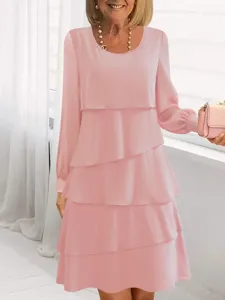 Primo piano dettagliato dell'elegante abito rosa a maniche lunghe con morbidi volant a strati.