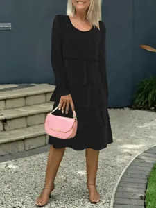 Vista dettagliata di abito nero a balze maniche lunghe da donna, scollo tondo stile midi.