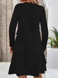 Vista posteriore dettagliata dell'elegante abito nero a maniche lunghe con balze.