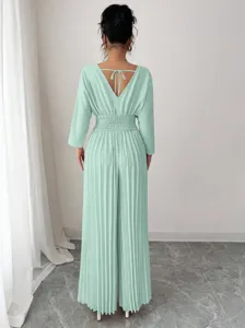 Detailed back view of an elegant mint green pleated jumpsuit with V-neck and tie.