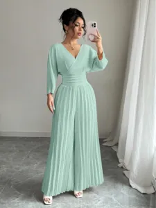 Detail shot of the mint green pleated jumpsuit featuring a V-neck and cinched waist.