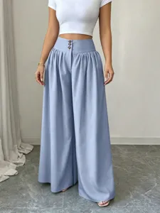 High-waisted wide-leg trousers detail showing three-button closure and draped fabric.