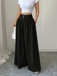 High-waisted wide leg trousers detail, featuring three button closure and drape fabric.
