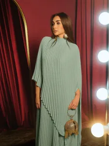 Close-up detail showcasing the elegant sage green pleated long sleeve dress and chic round clutch.
