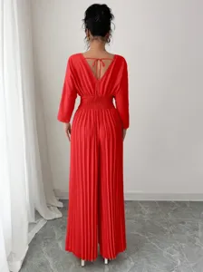 Detailed view of the elegant red pleated wide-leg jumpsuit showing back v-neckline and tie.