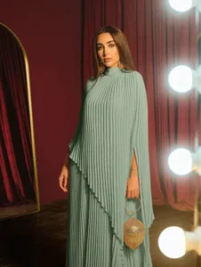 Detail view of a loose pleated mint green irregular dress with long sleeves and elegant style.