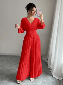 Detail view showing the red pleated wide-leg jumpsuit, elegant V-neck commuter style.