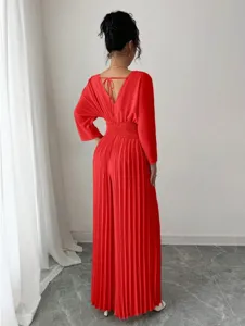 Detailed view of backless red pleated jumpsuit, V-neck design, elegant wide leg style.