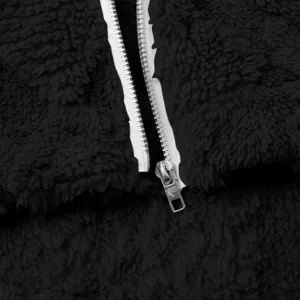 Schwarze Fleecejacke Reißverschluss Detail, weiche flauschige Textur Nahaufnahme.