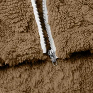 Nahaufnahme der braunen Fleecejacke mit Stofftextur und silbernem Metallreißverschluss.