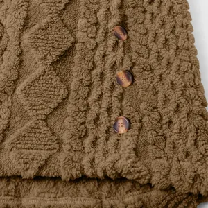 Braune flauschige Teddyfleece Jacken Detailaufnahme zeigt weiche Plüsch Textur mit Knöpfen