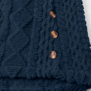 Nahaufnahme einer dunkelblauen Damen Fleecejacke mit weicher Textur und braunen Knöpfen.