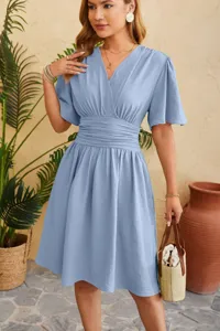 Detail view of the elegant light blue V-neck flared sleeve dress showcasing the waist design.