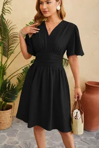 Detailed view of women's black V-neck flared sleeve dress with stylish waist design in scene.