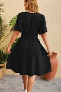 Close-up detail of the black flared sleeve and cinched waist design on the elegant dress.