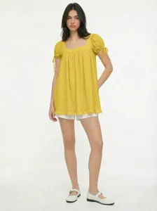 Scena di blusa gialla con collo quadrato, dettaglio maniche a palloncino estive.