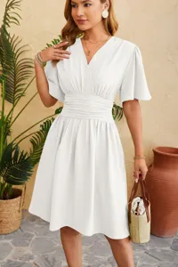 Elegant white V-neck dress detail showcasing bell sleeves and fitted waist for women summer wear.
