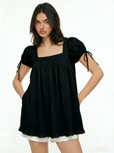Vista dettagliata della blusa nera con scollo quadrato, maniche a sbuffo e fiocchi.