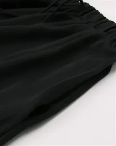Détail de jupe longue noire pour femme avec taille élastique à cordon et poches.