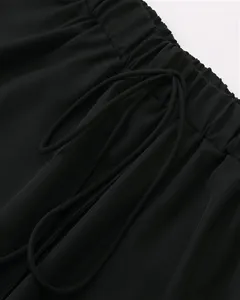 Jupe noire taille élastique cordon détail gros plan, texture tissu doux, style minimaliste.