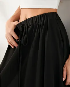 Gros plan sur la jupe longue noire à taille élastique avec cordon de serrage réglable.