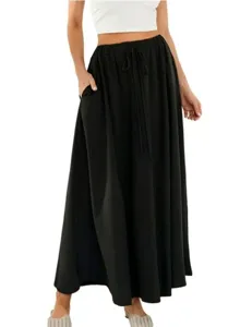 Détail de jupe longue noire avec taille élastique à cordon et poches latérales profondes.