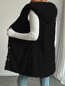 Close-up detail of the black fleece hooded vest showcasing textured fabric and side buttons.