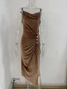 Sparkly velvet slip dress featuring a cowl neckline, ruched side slit and rhinestone buttons.