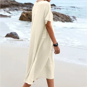Casual cotton linen midi dress walking on beach in summer, comfortable short sleeve design.