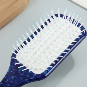 Blue marbled pattern hairbrush with soft air cushion and white pins for daily hair styling.