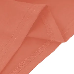 Detailopname van koraalkleurige effen stoftextuur met nette overlockstiksels en dubbele naaldzoom.