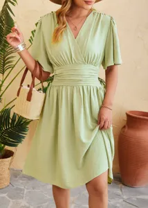 Details view of the elegant green V-neck dress, showcasing the stylish flare sleeves and waist line.