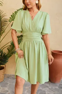 Green V-neck flare sleeve midi dress detail showing pleated high waist and textured fabric.