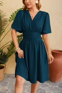Detail view of a chic V-neck waist-cinching flared sleeve midi dress in a rich teal shade.