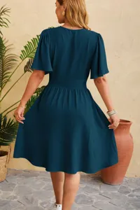 Back view detail of the elegant V-neck waist-cinching flutter sleeve dress in dark teal.