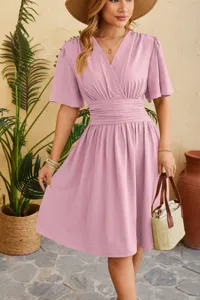 Detail view of the elegant pink V-neck dress, highlighting the cinched waist and delicate sleeves.