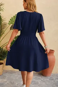 Back view detail of a navy blue V-neck flared sleeve dress showcasing back waist design.