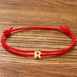 Red braided rope bracelet with gold letter R charm for couples and daily wear jewelry.