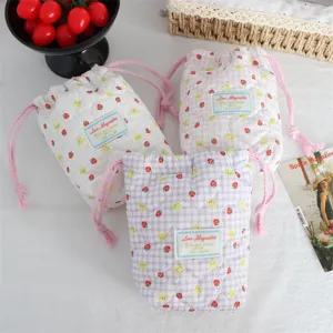 Quilted drawstring storage bag detail showing soft padding, cute strawberry and bunny print.