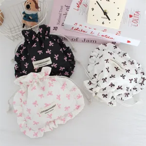 Vista detallada de bonita bolsa plisada con cordón, borde con volantes y patrón de lazos.