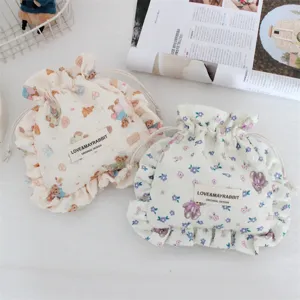 Detalle de bonita bolsa de almacenamiento portátil con cordón y diseño de oso plisado.
