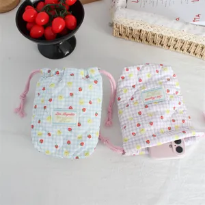 Close-up of quilted drawstring camera storage pouch with cute strawberry and bunny print.