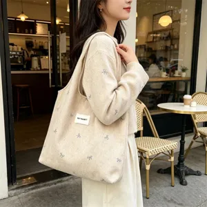 Casual gebreide shopper voor dames met schattige strik borduursel en schouderband.