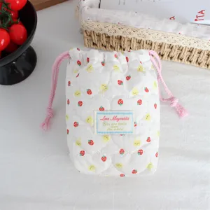 Quilted cotton drawstring pouch with cute strawberry and rabbit print, ideal for camera storage.