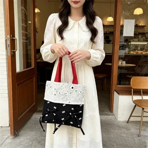 Süße süßes Canvas Tragetasche mit Spitzen-Patchwork, roten Henkeln und schwarzen Schleifen.