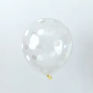 Close-up view of a transparent latex balloon with white polka dot pattern for parties