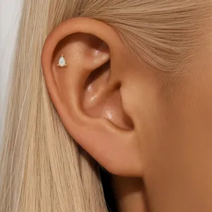 Detailed macro view of a pear-shaped white opal cartilage stud piercing earring